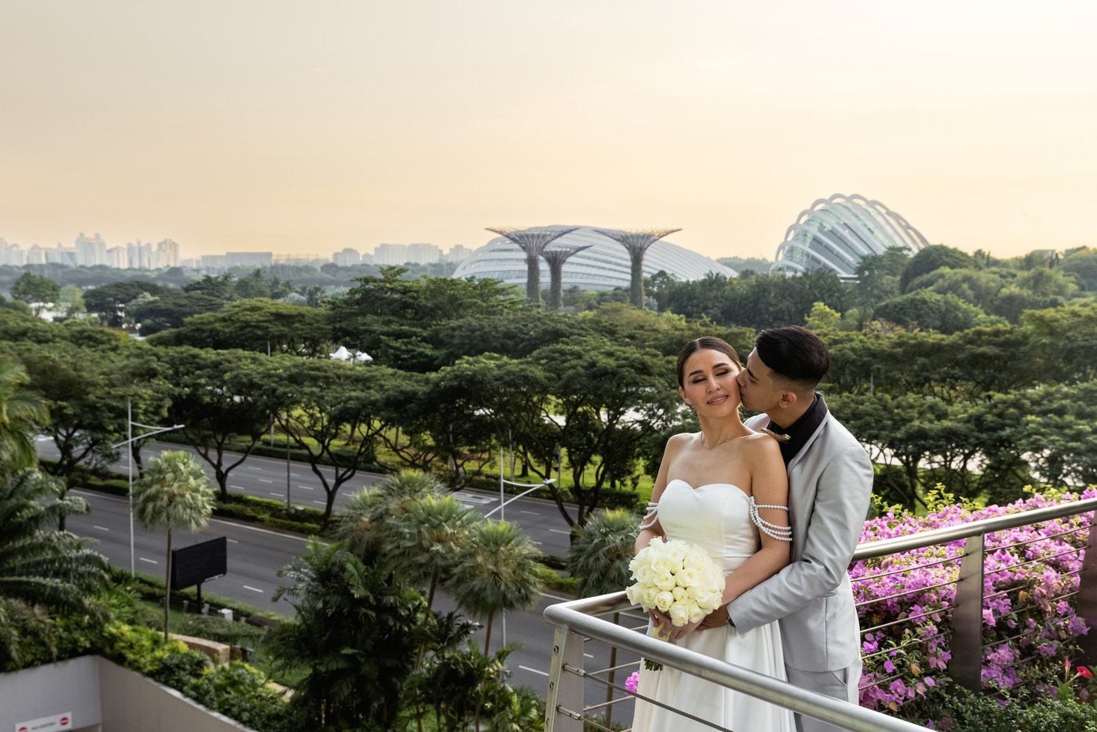 A beautiful wedding couple is kissing with Gardens by the Bay in Singapore